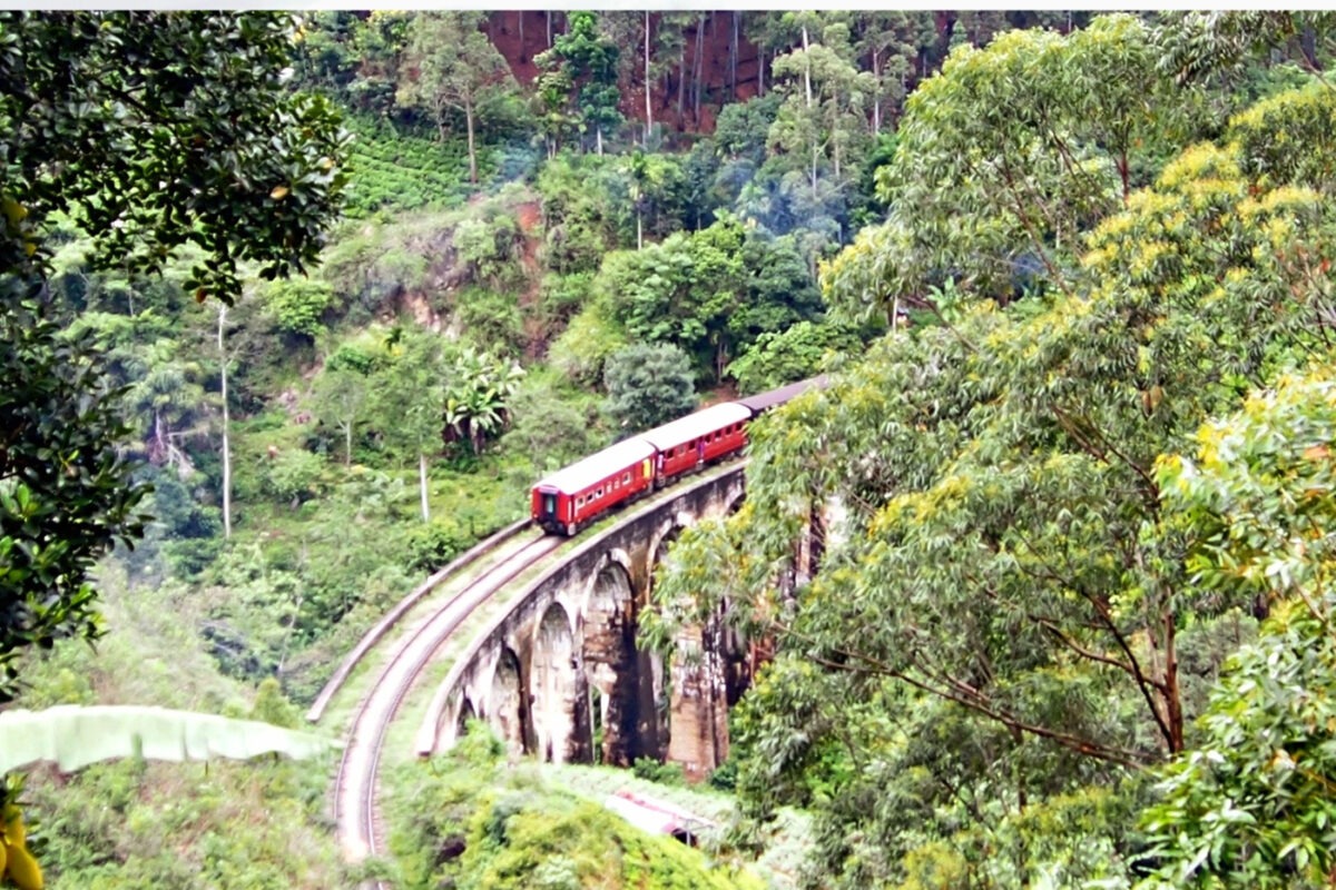 Steam train crossing 9 arches railway bridge