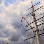 greenwich masts of a tall ship against a blue sky