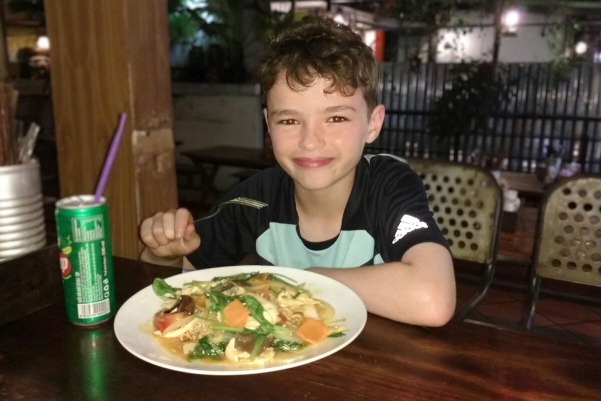 Happy child eating Vietnamese food in Saigon