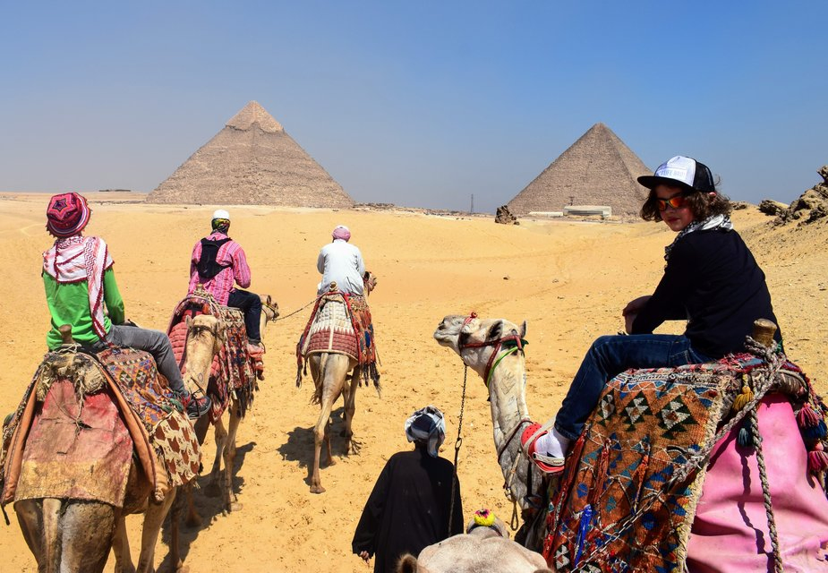 gigital nomad family with kids in desert with camels