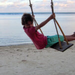 Thailand Western Kid on a beach on a swing