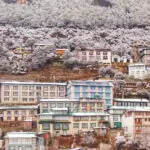 buildings on the mountainside in Namche Bazaar Nepal. A light covering of snow.