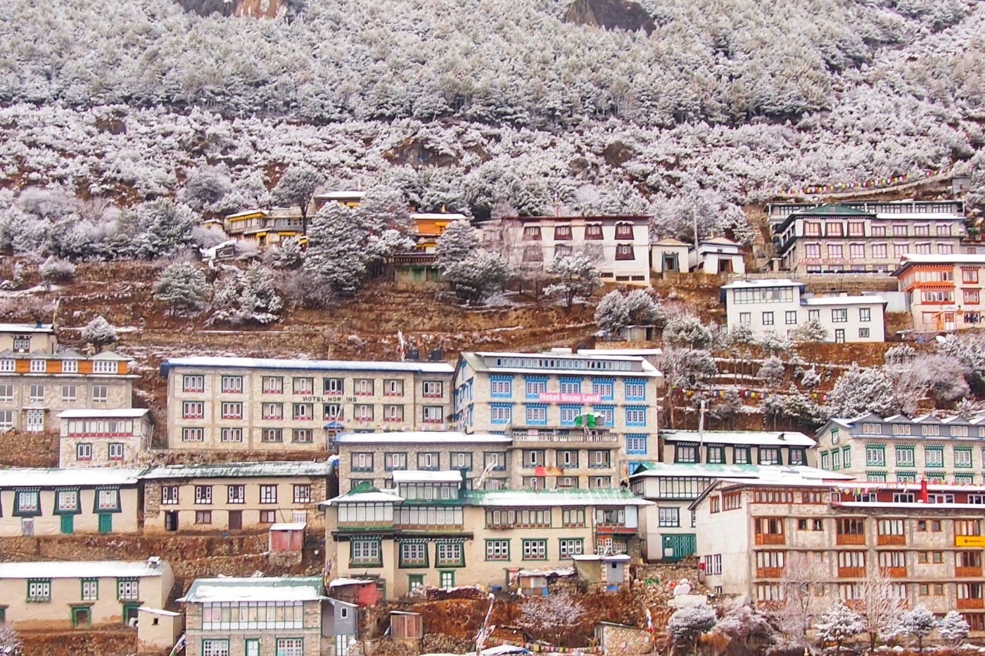 buildings on the mountainside in Namche Bazaar Nepal. A light covering of snow.