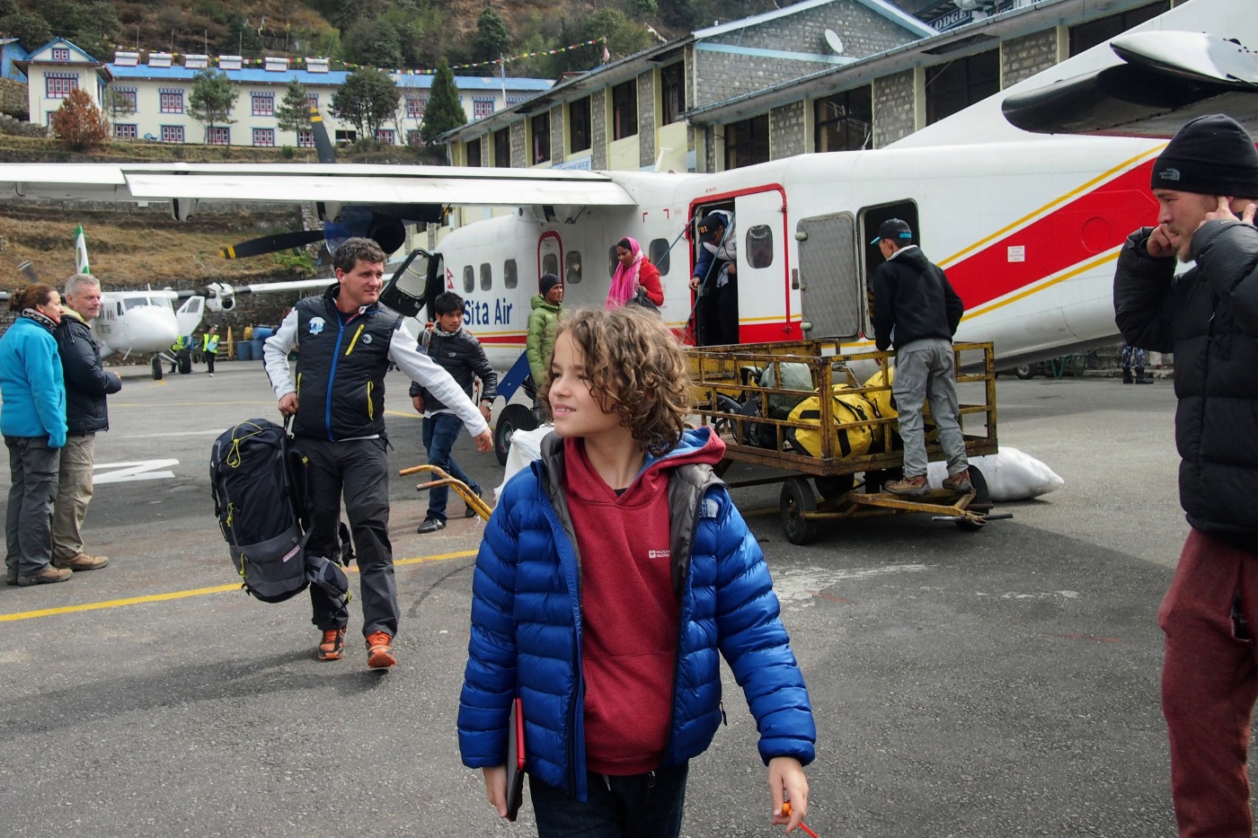 Child getting off a small plane at Lukla Airport Nepal