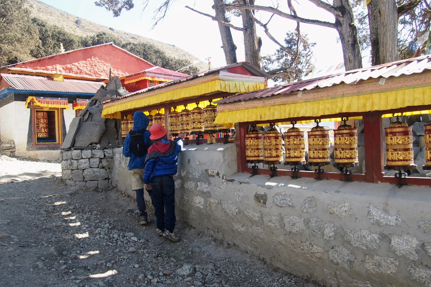 Kids on a trek in Nepal turning prayer wheels