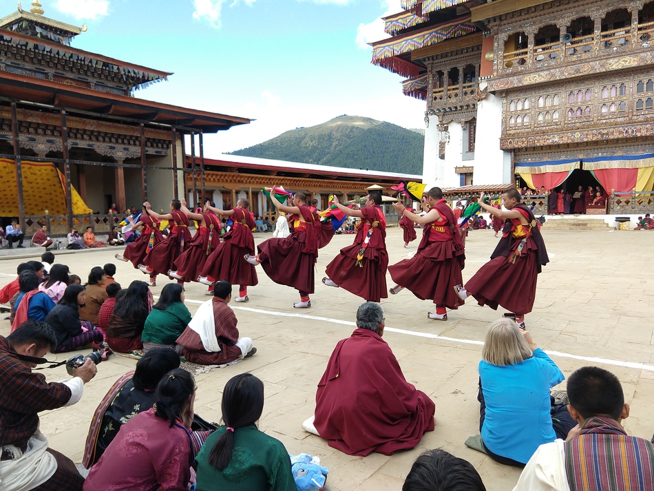 Tourists and locals watching a festival in Bhutan