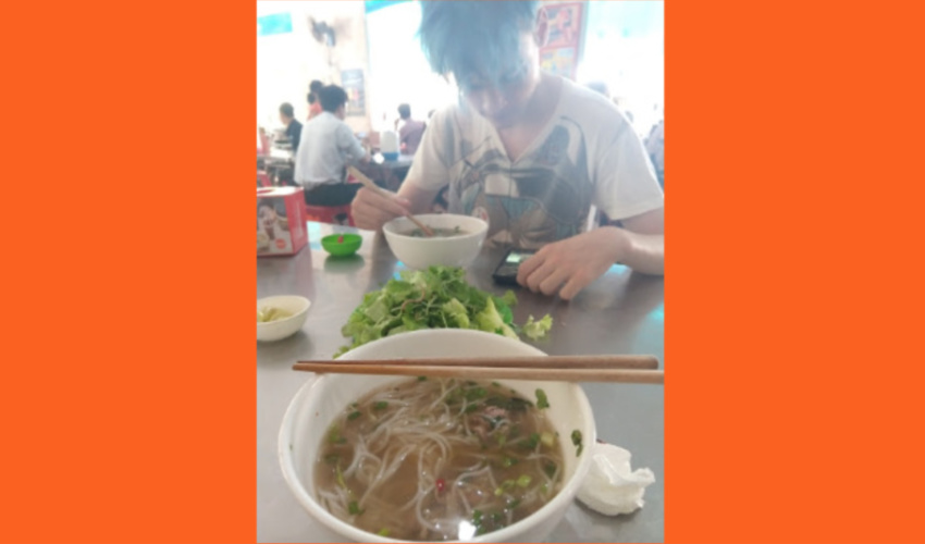 Eating Bun Bo Hue at a noodle shop in Hue City