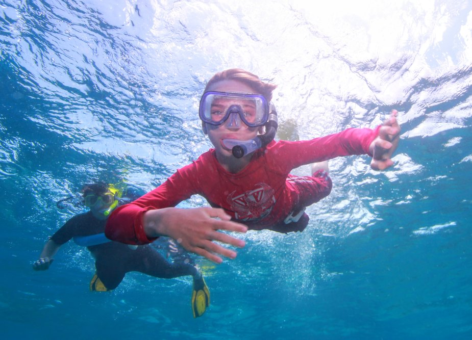 Child snorkelling on the great barrier reef from Port Douglas