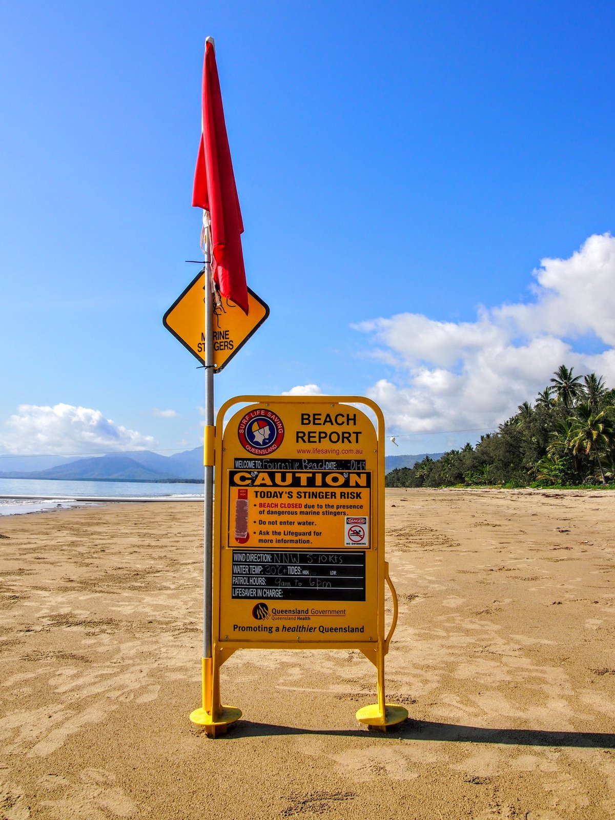 Port Douglas Beach Closed Sign on sandy beach