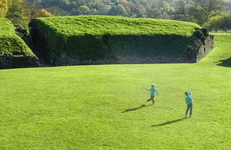 kids playing Roman Amphitheatre at Caerleon Wales
