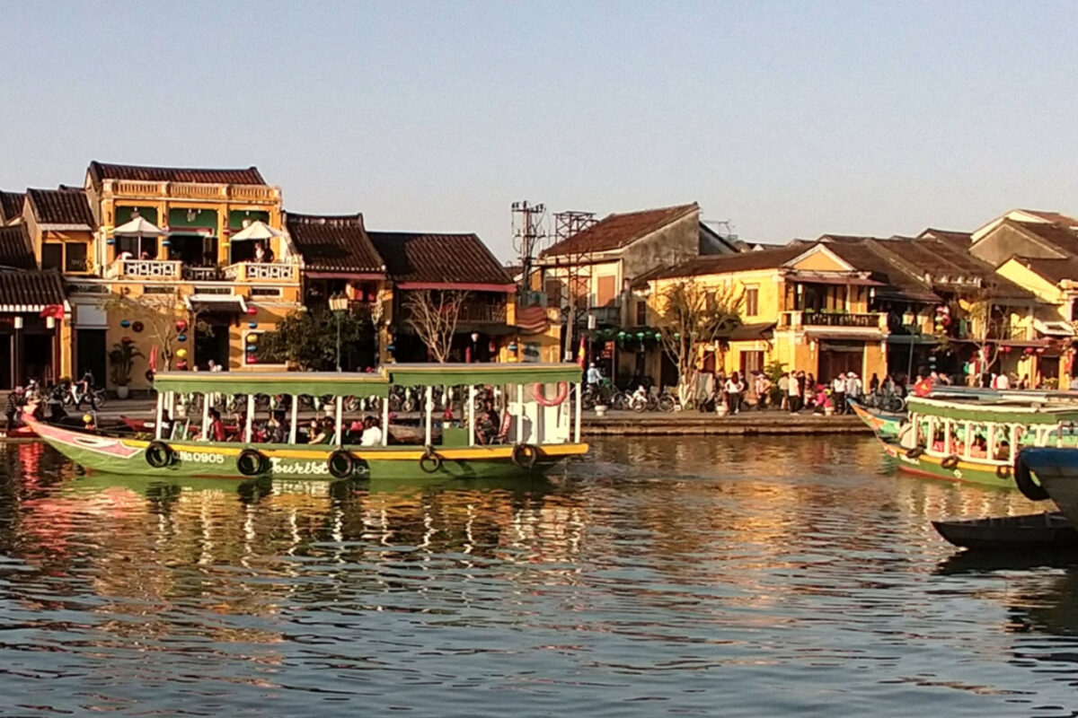 View of Hoi An Old Town. Yellow buildings, sampans and the river.