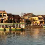 View of Hoi An Old Town. Yellow buildings, sampans and the river.