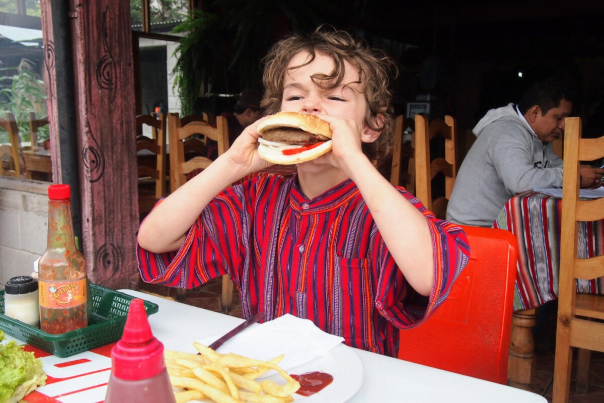 Child eating a burger in Guatemala.